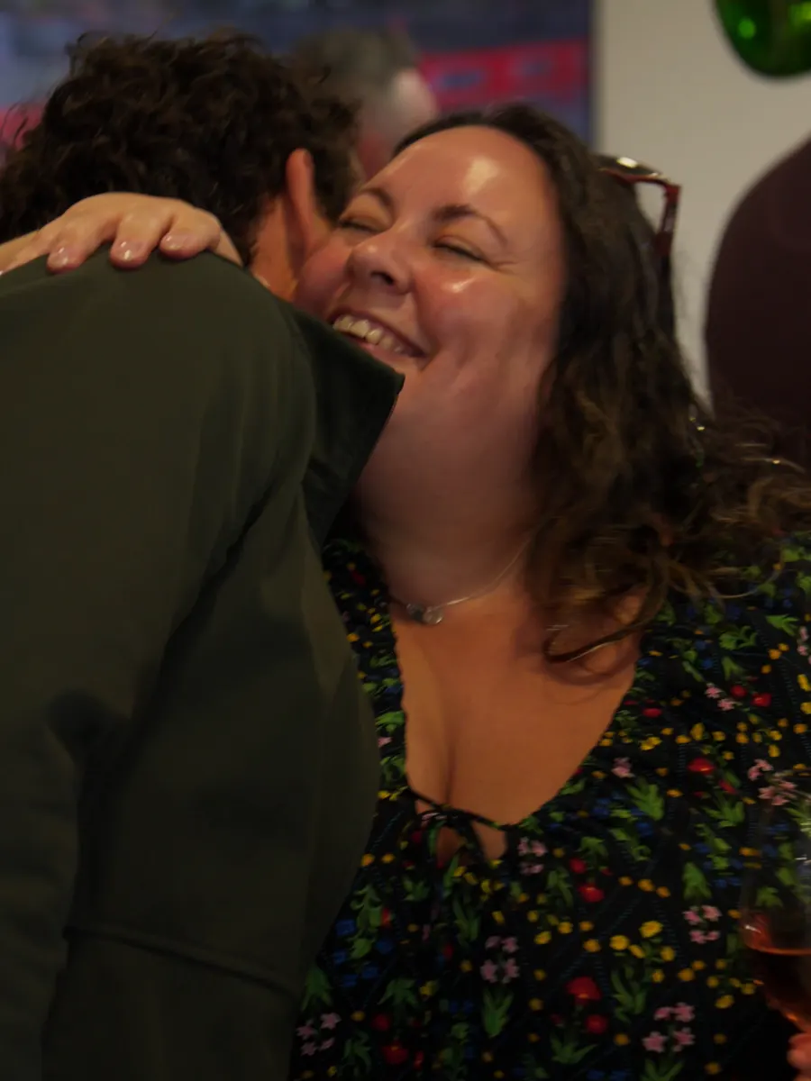 Two guests hugging and laughing in the Macaulay Motors showroom