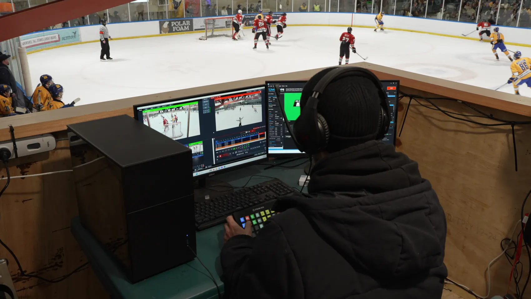 The live stream desk above the rink at the Queenstown Ice Arena during an NZIHL semi-final, with vMix on screen and a Stream Deck under hand